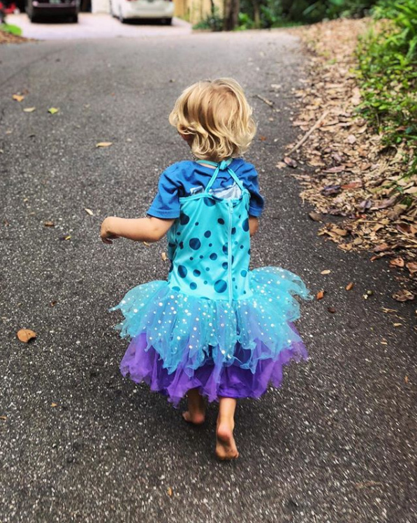 toddler boy in a blue sparkly dress playing dress up